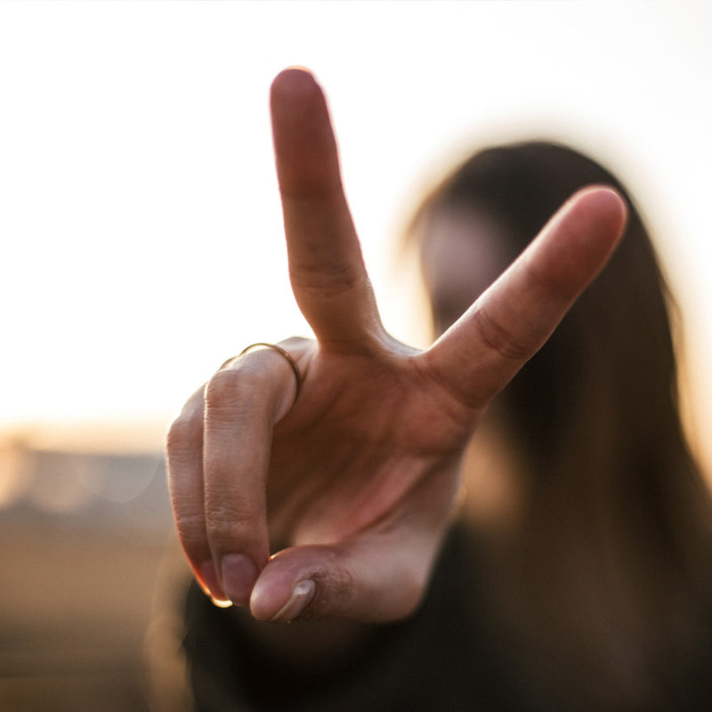 woman holding up peace sign