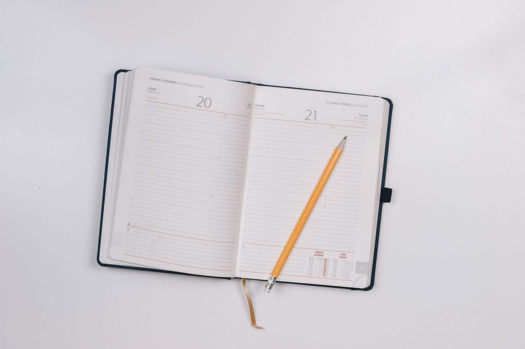 Pencil inside white diary. get organised image.