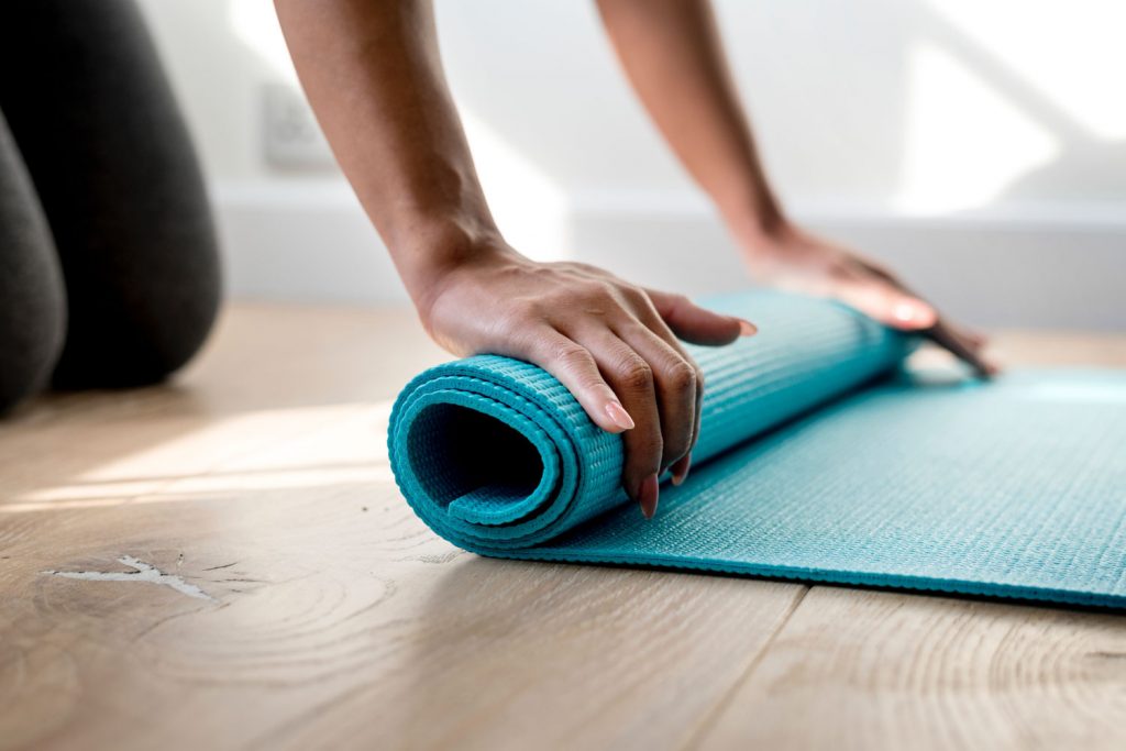 Woman rolling out Yoga mat